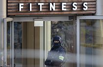Polizeibeamter steht vor dem Fitness-Studio in Duisburg, in dem die Messerattacke stattfand