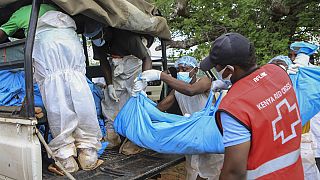 Police and local residents load the exhumed bodies of victims of a religious cult into the back of a truck in the village of Shakahola, Kenya Sunday, April 23, 2023