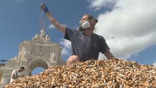 Andreas Noe mostra a pilha de 650 mil beatas de cigarros recolhidas numa semana