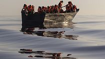 Migrantes com coletes salva-vidas fornecidos por voluntários da Ocean Viking, num barco de madeira a sul da ilha de Lampedusa. 27 agosto 2022