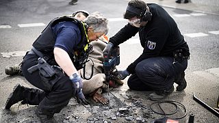 Police remove the asphalt next to the hand of an climate activist who glued his hand on the road, during a protest against the climate policy of the German government.