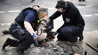 Полицейские пытаются отлепить активиста от асфальта. Берлин, Германия? 24 апреля 2023.