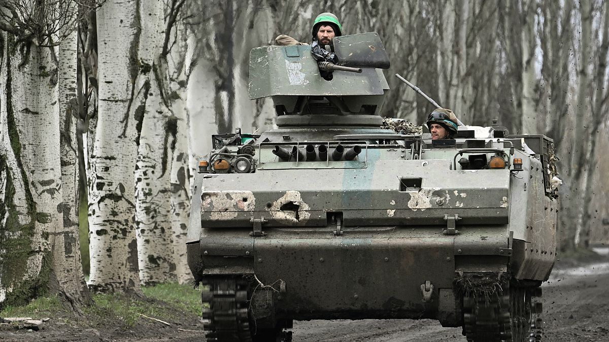 Des militaires ukrainiens à bord d'un véhicule blindé néerlandais YPR-765 sur une route près de Bakhmout, en Ukraine, 6 avril 2023. 
