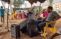 Суданцы ожидают автобуса, чтобы уехать из Хартума