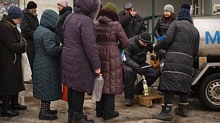 Des gens font la queue pour acheter du lait à Koupiansk, en Ukraine, le samedi 25 février 2023