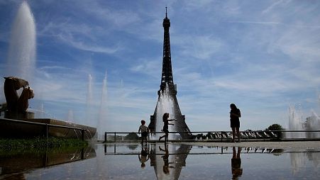 People cool down near the fountains of the Trocadero gardens in Paris, France, Wednesday, May 18, 2022. 