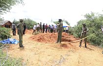 Polizisten am Tatort, wo die Polizei die Leichen von Opfern einer christlichen Sekte exhumiert, Shakahola am Rande der Stadt Malindi an der kenianischen Küste, 25. April 2023.