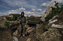 A Ukrainian soldier smiles standing in a trench on the frontline in the village of New York, Donetsk region, Ukraine, Monday, April 24, 2023.