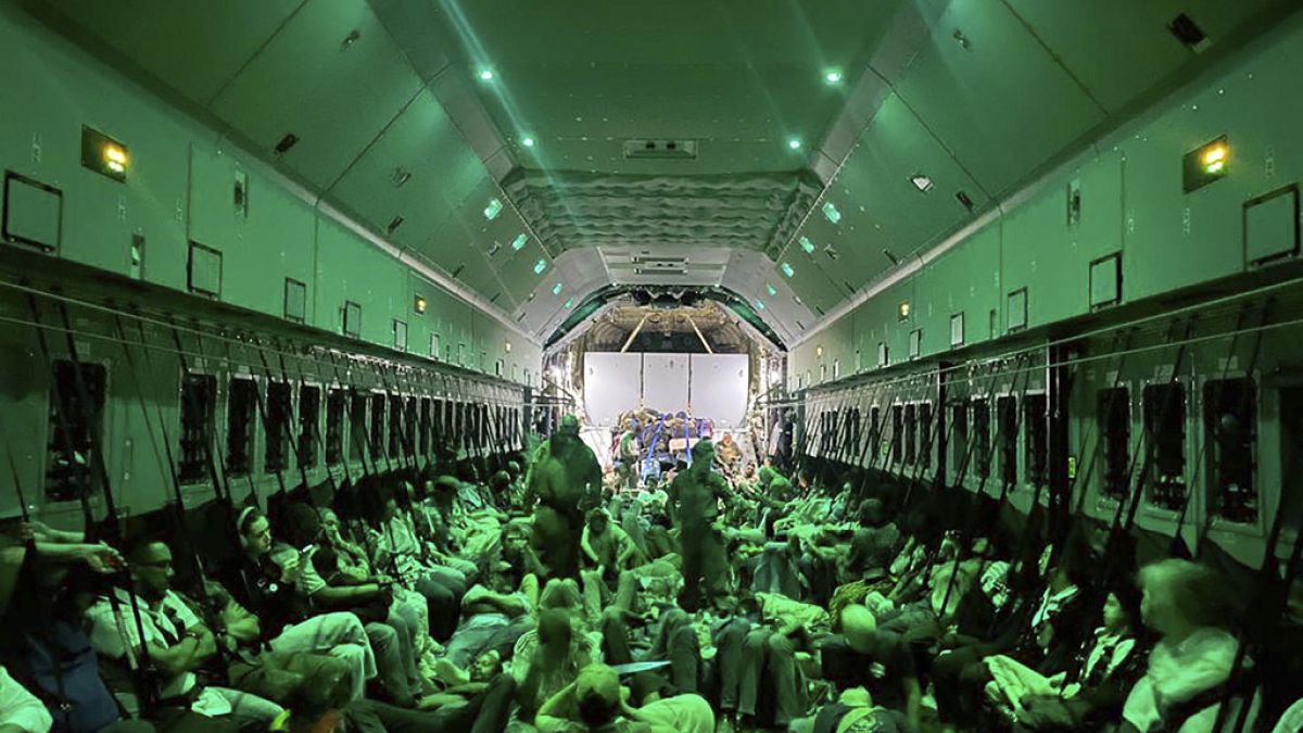In this photo provided by the Spanish Defence Ministry citizens of different nationalities, fleeing from Sudan, sit inside a Spanish Air Force aircraft on its way to Madrid.