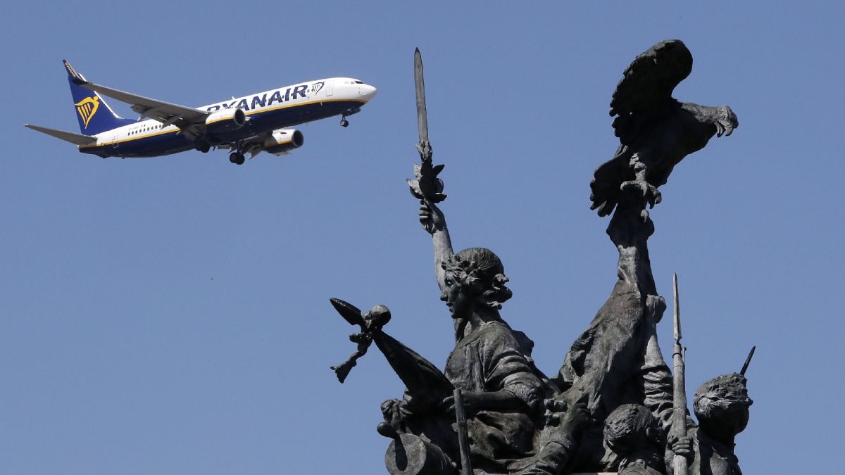 Ein Ryanair-Flugzeug im Landeanflug auf den Flughafen Lissabon fliegt am Denkmal für die Helden des Halbinselkriegs im Vordergrund vorbei.