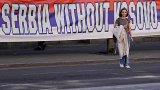 A woman passes by a billboard reading: ''Serbia without Kosovo would be like a human without heart'' at a protest in Belgrade. 24 March 2023
