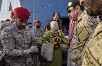 Eine ältere Frau erhält Unterstützung von Soldaten während einer Evakuierungsoperation aus dem Sudan