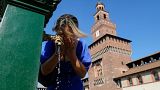 Eine Frau kühlt sich an einem öffentlichen Brunnen des Sforza-Schlosses in Mailand, Italien, ab.