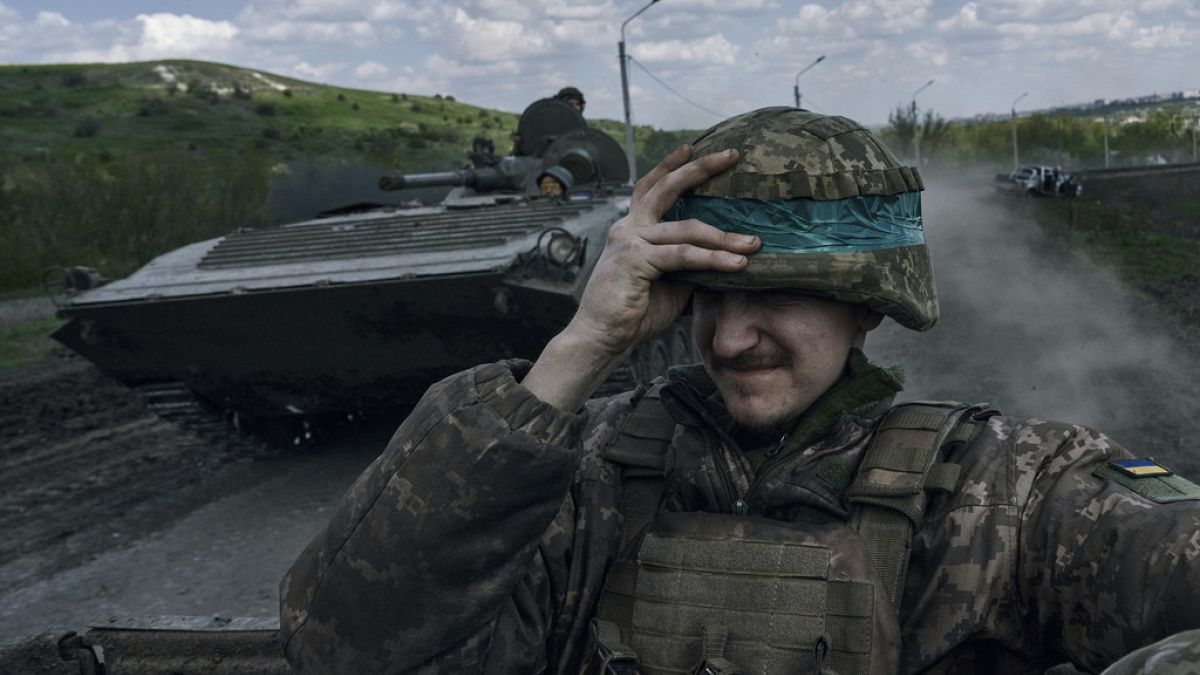 Egy ukrán katona tartja a sisakját egy harckocsin Bakmutban, a Donyecki területen, Ukrajnában, 2023. április 26-án