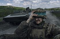 Egy ukrán katona tartja a sisakját egy harckocsin Bakmutban, a Donyecki területen, Ukrajnában, 2023. április 26-án