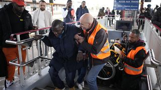 A disable man is helped climbing the stair to access the platform Wednesday, April 26, 2023 at the Melun train station, outside Paris.