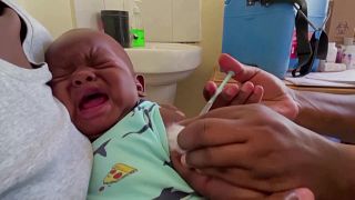 Nurse injecting vaccine into infant's arm in Kisumu, Kenya