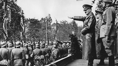 Adolf Hitler, front, salutes parading troops of the German Wehrmacht in Warsaw, Poland, on Oct. 5, 1939 after the German invasion. 
