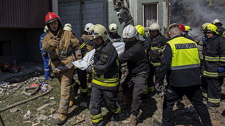 Firefighters carry a body recovered from the rubble of a residential building that was hit during a Russian attack in Uman, central Ukraine, Friday, April 28, 2023. 