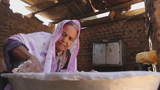 Sudan: Elderly woman in border town with Egypt shares bread with displaced people