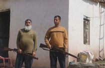 رجلان من سكان دنغاري يحملان بندقيتان