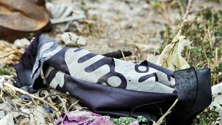 This picture taken on March 24, 2019 shows a discarded Islamic State (IS) group flag lying on the ground in the village of Baghouz in Syria's eastern Deir Ezzor province.