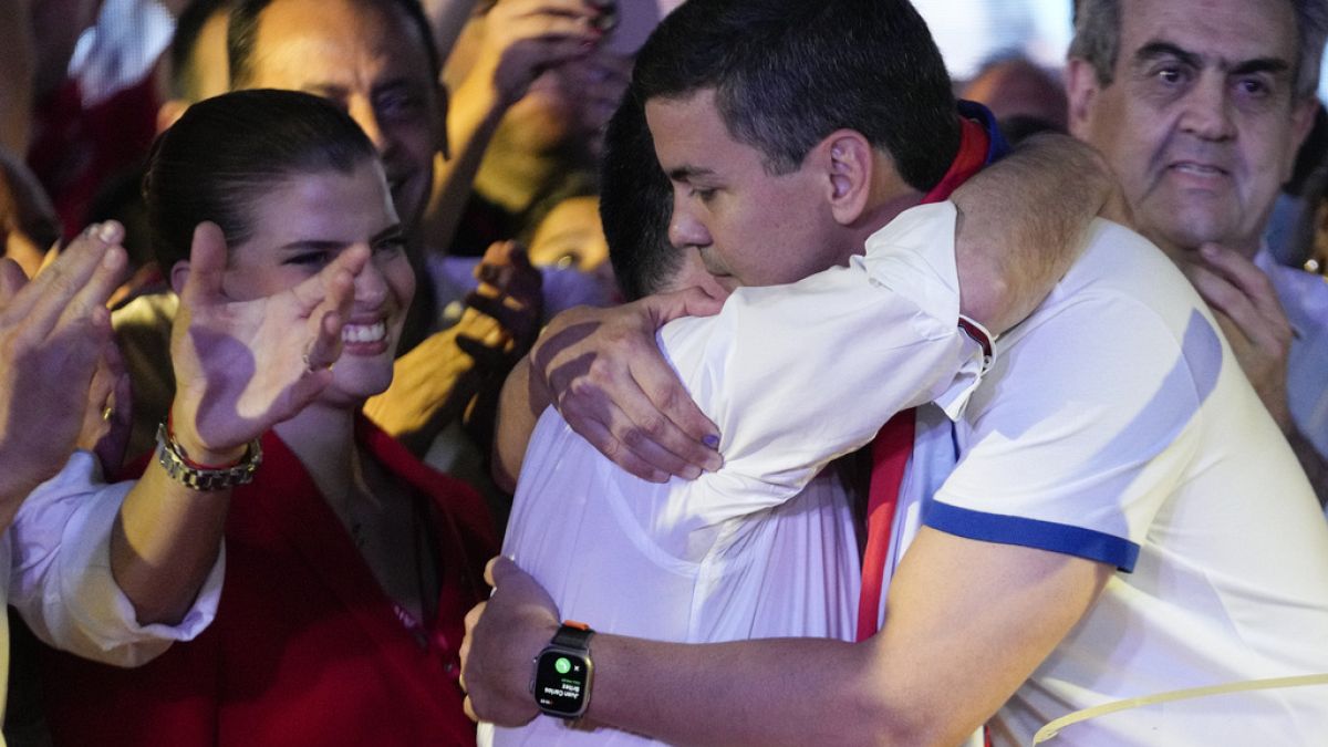 Santiago Peña, presidential candidate of the Colorado ruling party, right, embraces former President Horacio Cartes after the voting closed during general elections.