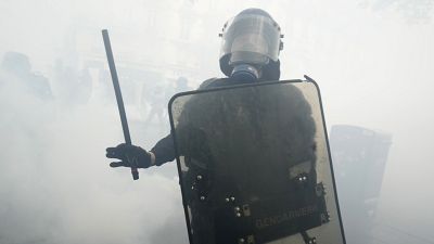 Ein Polizist steht inmitten von Tränengas-Schwaden während einer Demonstration am Maifeiertag in Paris