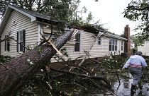 Eine Frau steht vor ihrem vom Sturm zerstörten Haus in Virginia Beach, USA
