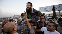 Palestinian Khader Adnan, center, is greeted by Palestinians after his release from an Israeli prison in the West Bank village of Arrabeh near Jenin, Sunday, July 12, 2015.