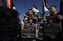 Palestinian kids wave their national flag and hold posters showing Khader Adnan, a Palestinian Islamic Jihad militant who died in Israeli prison. May 2, 2023