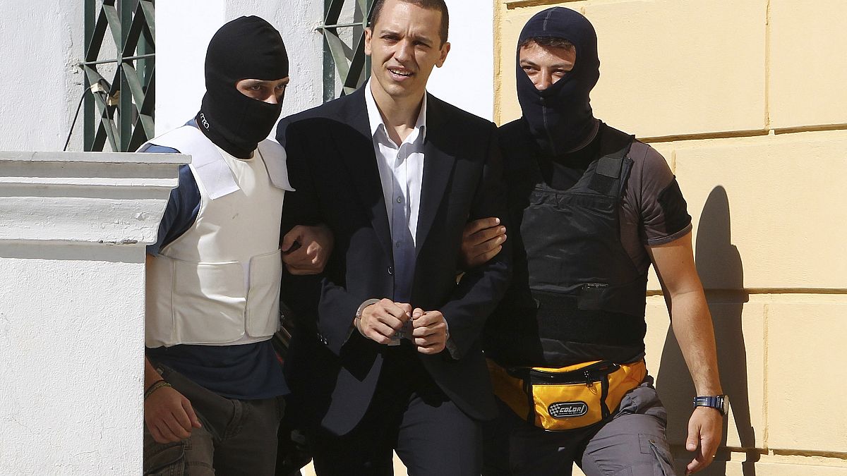 Archivo: Ilías Kasidiari, líder del partido de extrema derecha Amanecer Dorado, escoltado por la policía antiterrorista hasta el tribunal. Atenas, 1 de octubre de 2013.