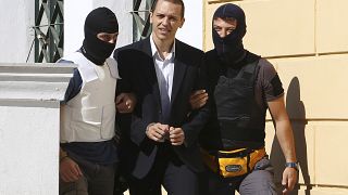 Archivo: Ilías Kasidiari, líder del partido de extrema derecha Amanecer Dorado, escoltado por la policía antiterrorista hasta el tribunal. Atenas, 1 de octubre de 2013.