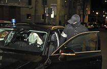 Agente da polícia entra num carro onde um suspeito se encontra deitdo, após uma rusga, esta quarta-feira, em Hagen, na Alemanha