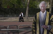 Police officers patrol besides a life-size cardboard of Britain's King Charles III in London
