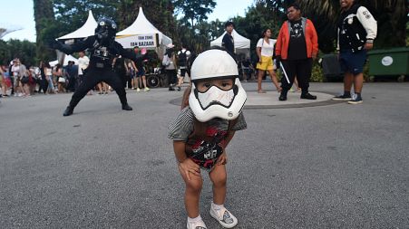 A young fan with a Stormtrooper mask looks on during a festival marking Star Wars Day