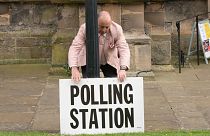 A polling station sign is adjusted outside the polling station in Bridlington, England, Thursday, May 4, 2023. 