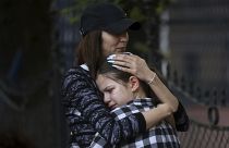 Eine Frau umarmt ein trauerndes Mädchen nach dem Schulamoklauf in Belgrad