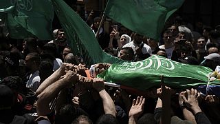 Palestinianos transportam o corpo de Hassan Qatnani, coberto com a bandeira do grupo militante Hamas, durante o seu funeral na cidade de Nablus, na Cisjordânia