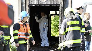 Firefighters and police investigators gather at the scene of a fatal fire in Plotni Street in Brno, Czech Republic, Thursday, May 4, 2023.