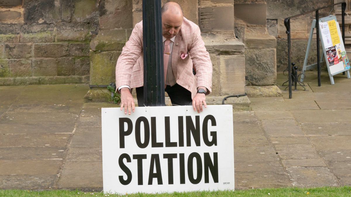 A polling station sign is adjusted outside the polling station in Bridlington, England, Thursday, May 4, 2023.