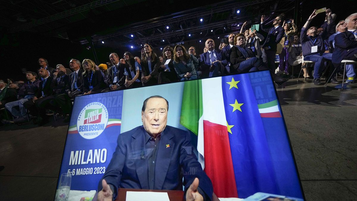 Ecrã a difundir a mensagem de Berlusconi na convenção do Força Itália