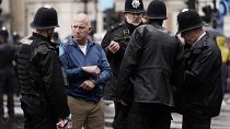 عناصر من الشرطة البريطانية تلقي القبض على مشارك خلال مراسيم تتويج تشارلز الثالث في لندن، بريطانيا. 
