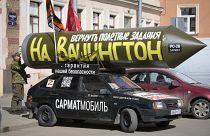 A pro-Kremlin activist standing by his mock Russian missile reading "Let's program it again to target Washington", in St. Petersburg, Russia, Friday, April 14, 2023