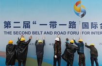 Workers putting up a 'Belt and Road' initiative sign in China.