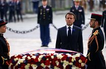 French President Emmanuel Macron lays a wreath of flowers at the Tomb of the Unknown Soldier.