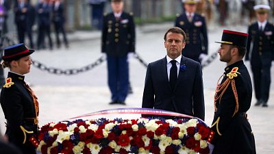 French President Emmanuel Macron lays a wreath of flowers at the Tomb of the Unknown Soldier.