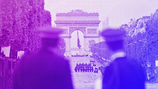 Police officers watch members of the French Republican Guard riding horses up the Champs-Elysees avenue on 8 May 2023