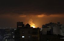 Smoke and flames rise above buildings after an Israeli airstrike in Gaza City
