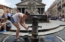 Una mujer se refresca en una fuente de la plaza del Panteón de Roma